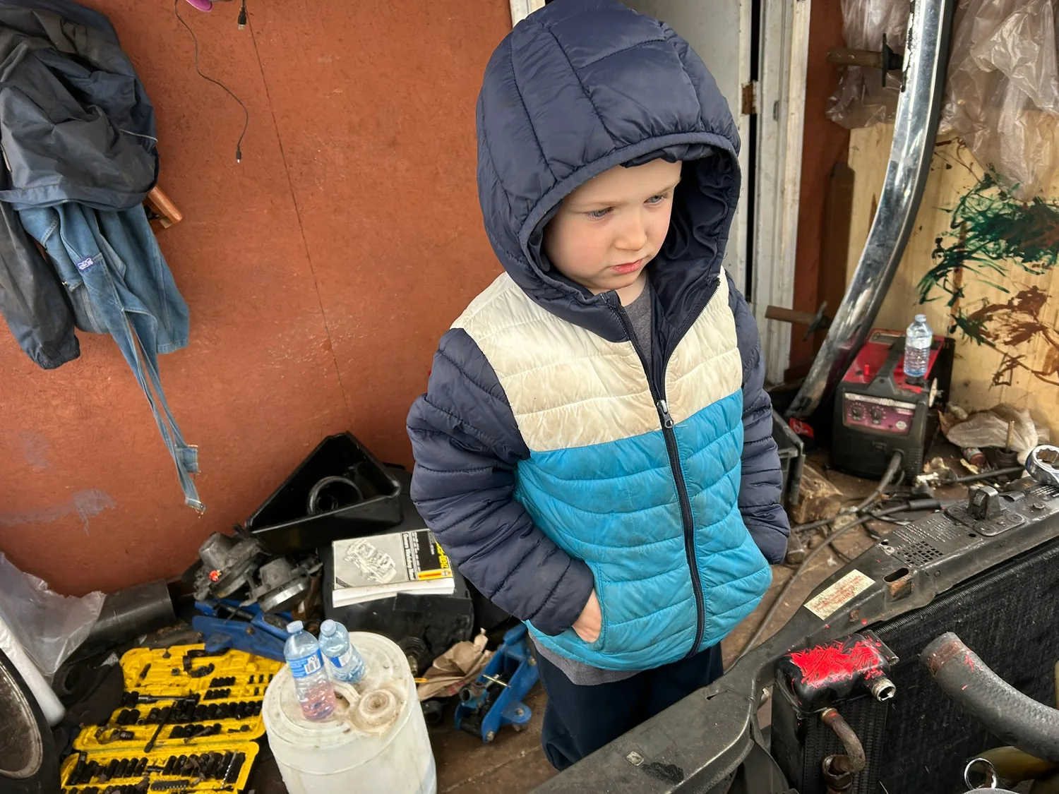 Elijah bundled up in his winter jacket in the workshop